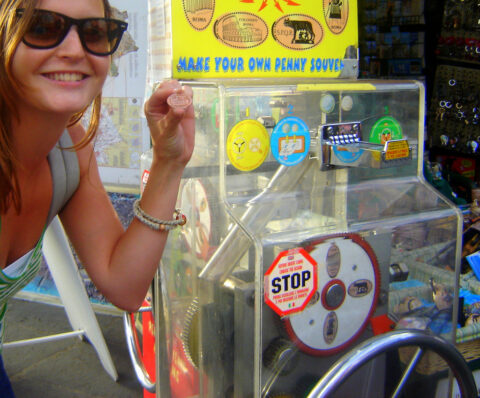 Using an elongated penny souvenir machine at a popular tourist attraction. 