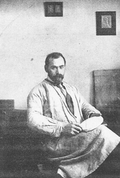 Here, Victor David Brenner is seated in a studio with a plaster model of the large design for the Lincoln cent. 